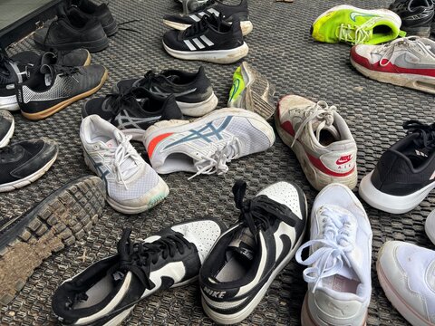 ensemble de chaussures de diff&eacute;rentes marques enlev&eacute;es &agrave; l'entr&eacute;e d'une salle