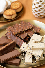 Christmas Spanish holiday treats, chocolate turron with whole almonds, creamy nougat, and polvorones