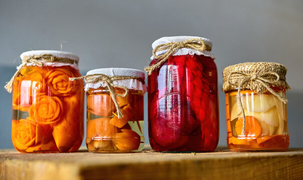Colorful jars of preserved fruits and vegetables showcase home canning skills in a rustic kitchen setting