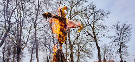Scarecrow burning symbolizing spring arrival and new beginnings in the countryside with copy space