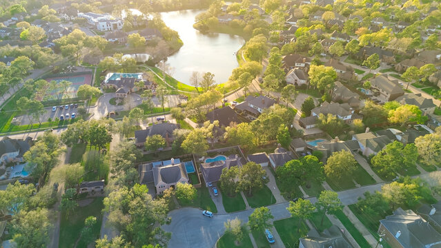 Lighted tennis courts in upscale lakeside gated residential neighborhood along Eldridge Parkway unincorporated area community northwestern Harris County, Houston, expensive mansion home pools