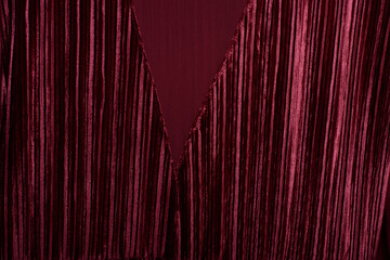 Luxurious deep red velvet curtain, draped beautifully with rich folds.