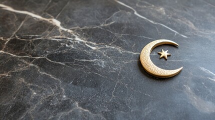Crescent moon and star placed on a dark marble surface with veining