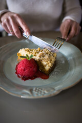 A woman is relaxing in a restaurant and drinking hot sea buckthorn tea with carrot cake