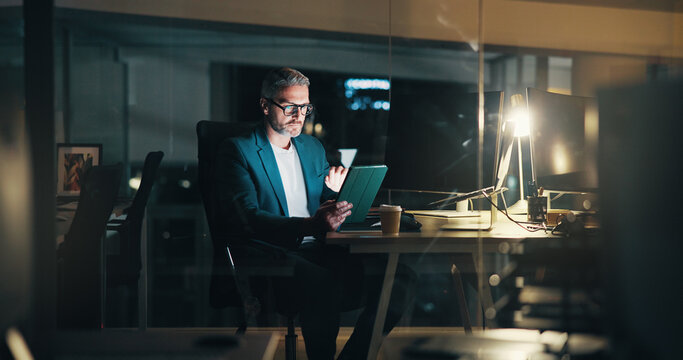 Man, night and typing on tablet in office, financial consultant and online for trading trend. News, expert advisor and email international client for update on stock, deadline and mature person