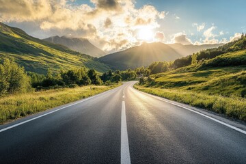 Naklejka premium Scenic mountain road at sunset. Vast, winding asphalt highway through verdant hills, leading towards a sunlit horizon, framed by majestic mountains