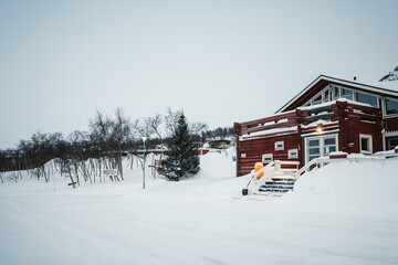 Fototapeta premium Hostel sign by snowy driveway in Kilpisjarvi, Finnish Lapland in winter.