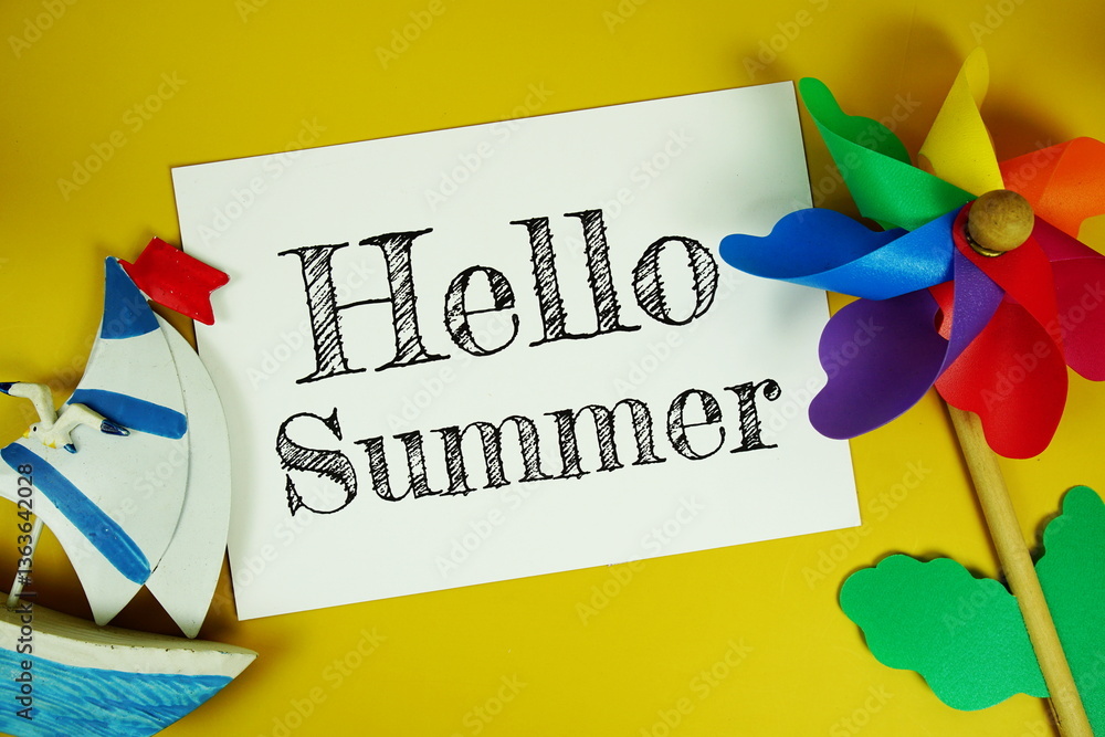 Poster hello summer text on paper card with colorful pinwheel top view on yellow background