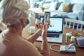 Senior woman having video call with doctor from home