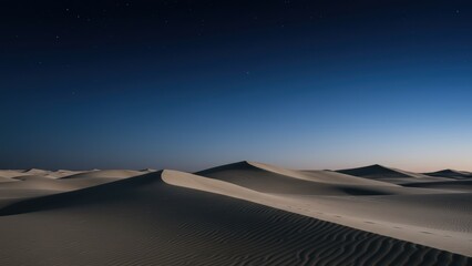 Naklejka premium Serene sand dunes under a dark, star-filled night sky at twilight.