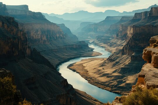 A picturesque scene of the Grand Canyon with clear blue skies and a flowing river. The rocky cliffs provide a dramatic backdrop for this natural wonder.