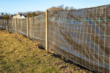 Silt Fence fabric with wire mesh and wooden posts installed prior to the start of construction.
