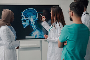 Medical team examining a skull x ray on a digital display
