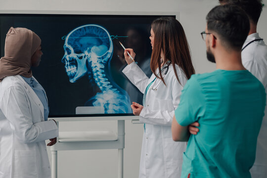 Medical team examining a skull x ray on a digital display - Powered by Adobe