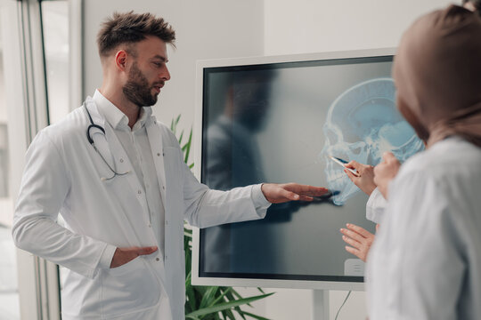 Doctors examining skull x ray on interactive whiteboard in hospital
