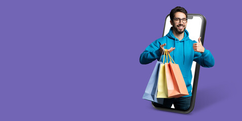 A smiling buyer holds shopping bags while interacting with a smartphone. The vibrant background...