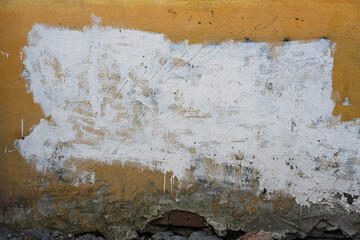 Old Yellow Wall with White Paint Patch
Weathered yellow wall featuring a large, rough white paint...