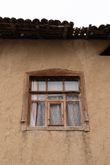 Weathered Wooden Window on a Rustic Wall in Snow