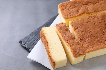 Tasty Japanese Castella sponge cake on grey table, closeup. Space for text