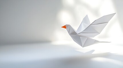 Delicately folded white origami dove with orange beak in flying position, representing peace and artistry