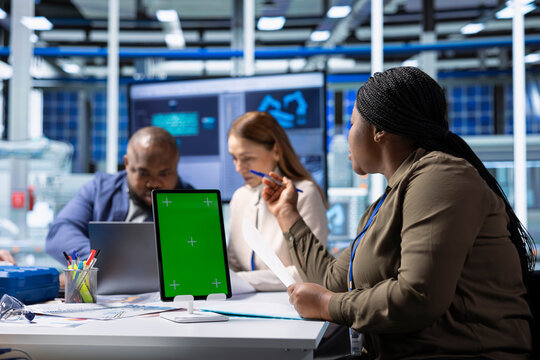 Shareholders use mockup device to project returns, assessing deal feasibility. Accountant in office using isolated screen tablet, performing financial analysis for interested investors