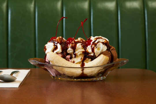 Banana split in front of green banquet at diner
