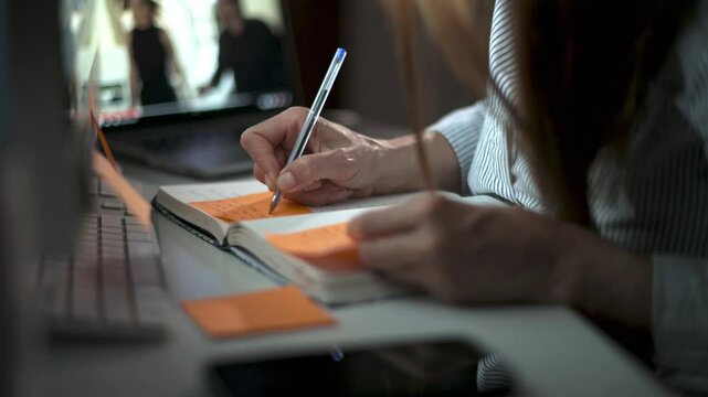 Crop woman writing in notepad