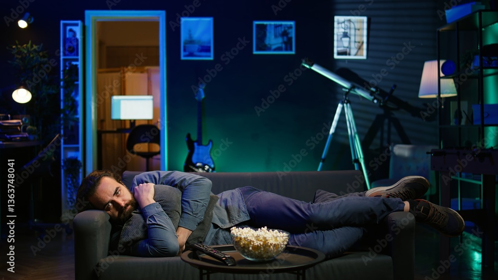 Poster man laying down hugging pillow watching tv, heartbroken by upsetting movie plot. sad viewer lounged 