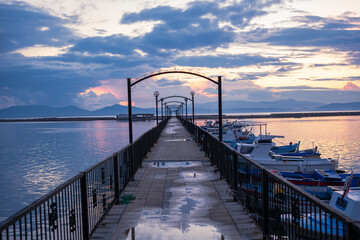 Fototapeta premium Symmetrical pier with boats at golden hour