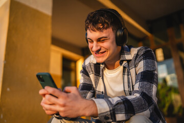 Fototapeta premium young man student sit in front university listen music and enjoy