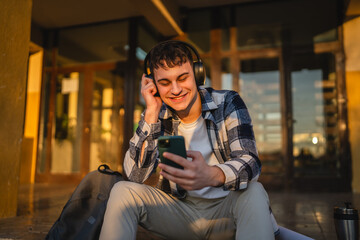 young man student sit in front university listen music and enjoy