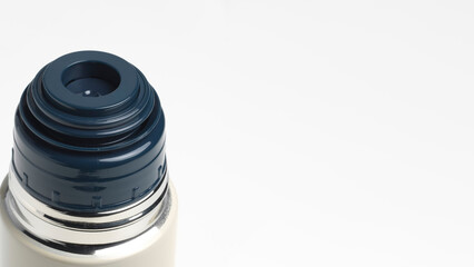 Closeup of stainless steel water bottle with plastic blue cap on copy-space background.