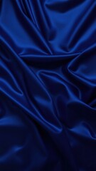 Obraz premium Beautiful dark blue silk satin background. Soft folds on shiny fabric. Luxury background with copy space for text, design. Web banner. Flat lay, top view.