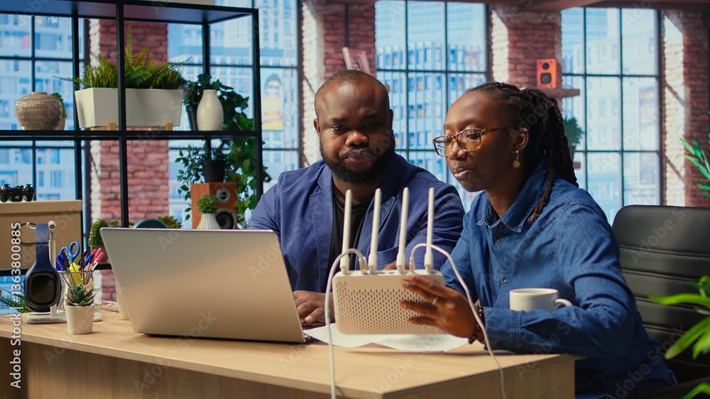 Poster african american couple at home office troubleshooting their wi fi modem and discussing solutions to