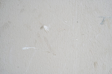 A close-up of a textured white wall with subtle imperfections and roughness. The uneven surface...