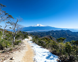 Panoramic mountain vista with snow-dusted trail