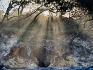 Sun streaking through cliffs and sea spray, Coolum Beach, Sunshine Coast, Queensland, Australia