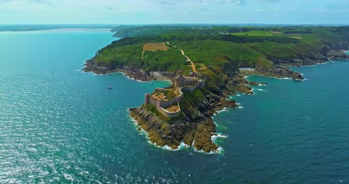 Aerial view of Fort La Latte, Chateau de la Roche Guyon in Cap Frehel, Brittany, France, on a sunny day in summer with waves crushing on the sandstone cliffs