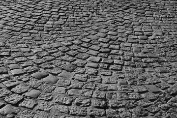 Old cobblestone road top aerial drone perspective view. retro aged cobble stone street pattern background. Cobblestone. Ancient rock floor texture top view. Sunny summer day Golden sunset hour Evening