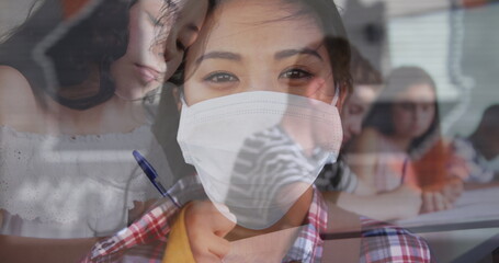 Digital composition of asian woman wearing face mask against college student studying at college