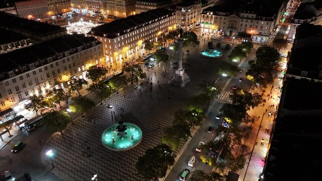 Dom Pedro Iv Square At Lisbon District Of Lisbon Portugal. Aerial View Of Lush Green Park And Surrounding Buildings. Night Elevated Road Downtown Cityscape. Night Panoramic City.
