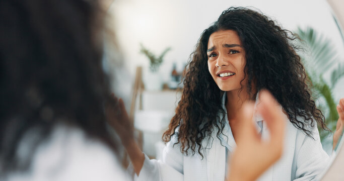 Frustrated, woman and hair care crisis in bathroom for frizz, knot and split ends in house. Confused, mirror and upset female person with worry or stress for dry texture, dandruff or scalp damage - Powered by Adobe