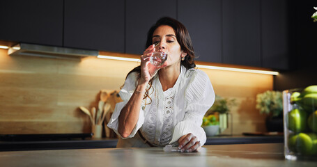 Woman, medicine and drink water in kitchen for supplement pills, vitamins and tablets for...