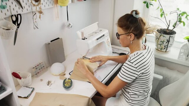 Fashion designer tests textile samples before assembling outfit, ensuring best material selection. Well-organized sewing studio provides tools and resources for high-quality garment production.
