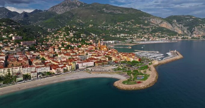 Aerial view of Menton, France. The colourful old town of Menton in summer, with historic buildings and beautiful beach at sunset. Aerial shot of historic church and colorful rooftops