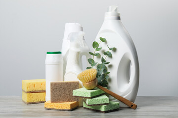 Eco-friendly cleaning products, supplies and eucalyptus branches on wooden table