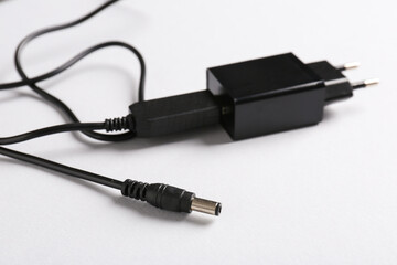 USB power adapter with charge cable on white background, closeup. Space for text