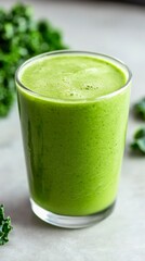 Bright green smoothie made with fresh ingredients in a clear glass, surrounded by leafy greens in a kitchen setting during daylight