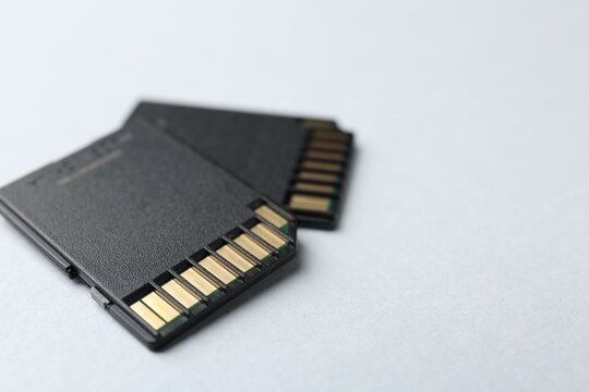 Two SD memory cards on white background, closeup. Space for text