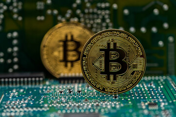 Moneda dorada Bitcoin en una placa de circuito electrónico de ordenador